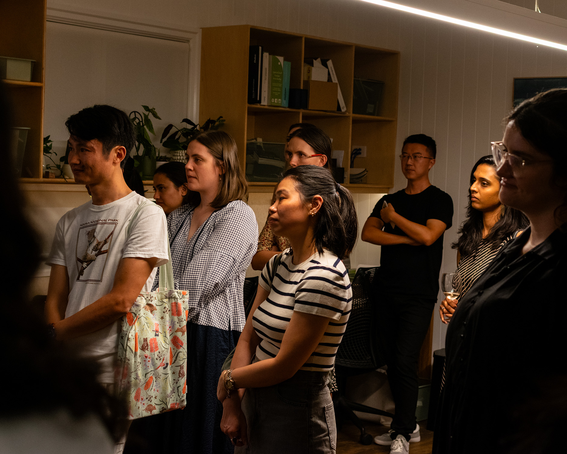 group of young people looking and listening thoughtfully to someone speaking